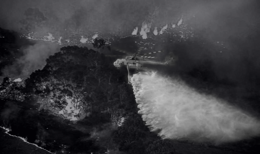 Firefighting helicopter conducting aerial water bombing